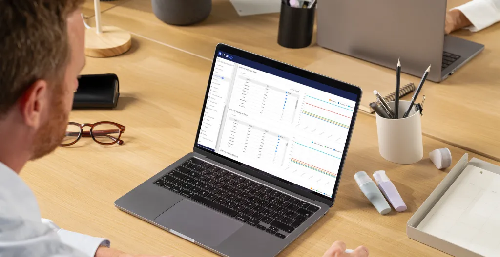Um homem sentado em frente ao um de notebook com um dashboard com dados de pneus aberto.